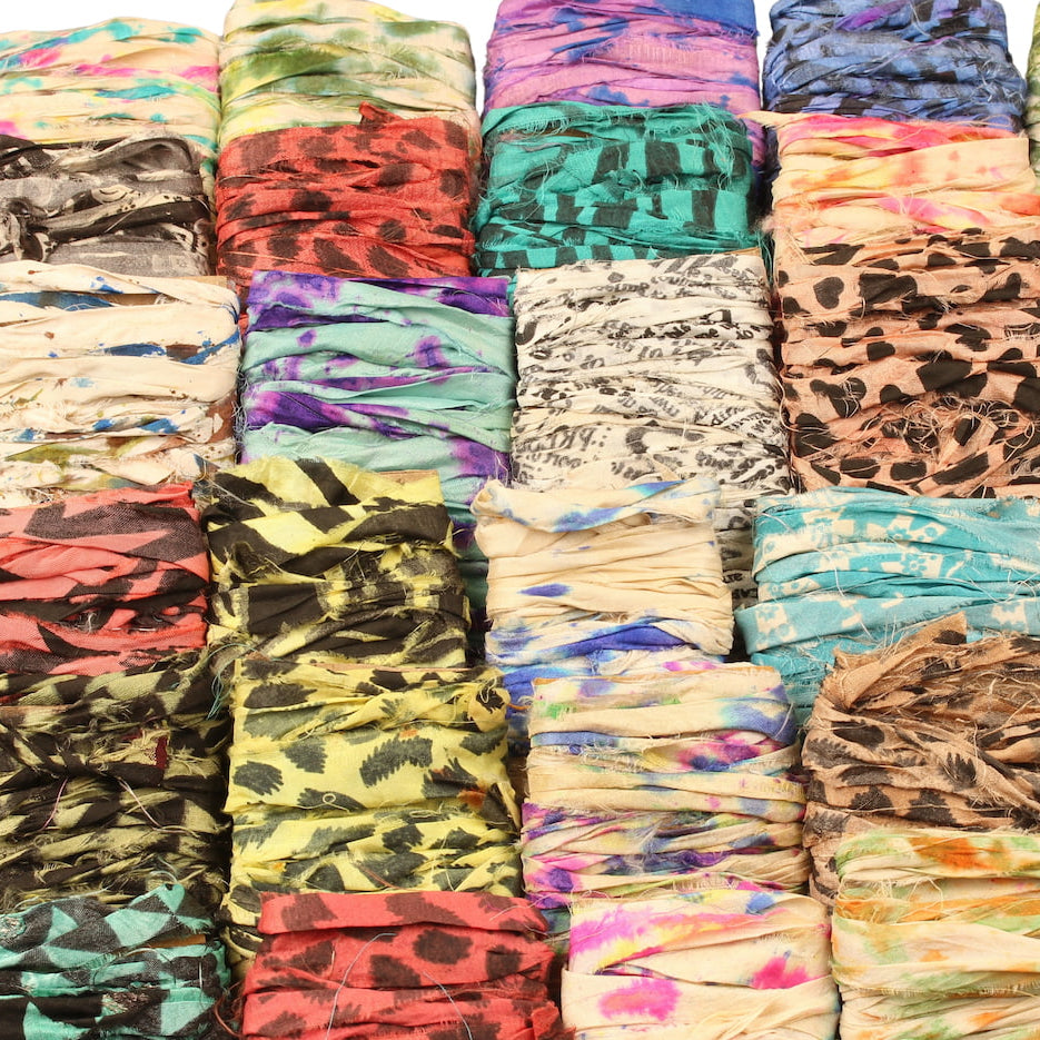 Assorted specialty sari silk ribbons in tie-dye and block print, 34 shades displayed on cardboard