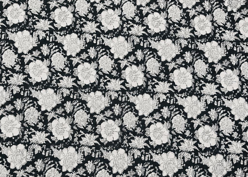 Black and white floral block printed cotton fabric featuring a repeating botanical pattern