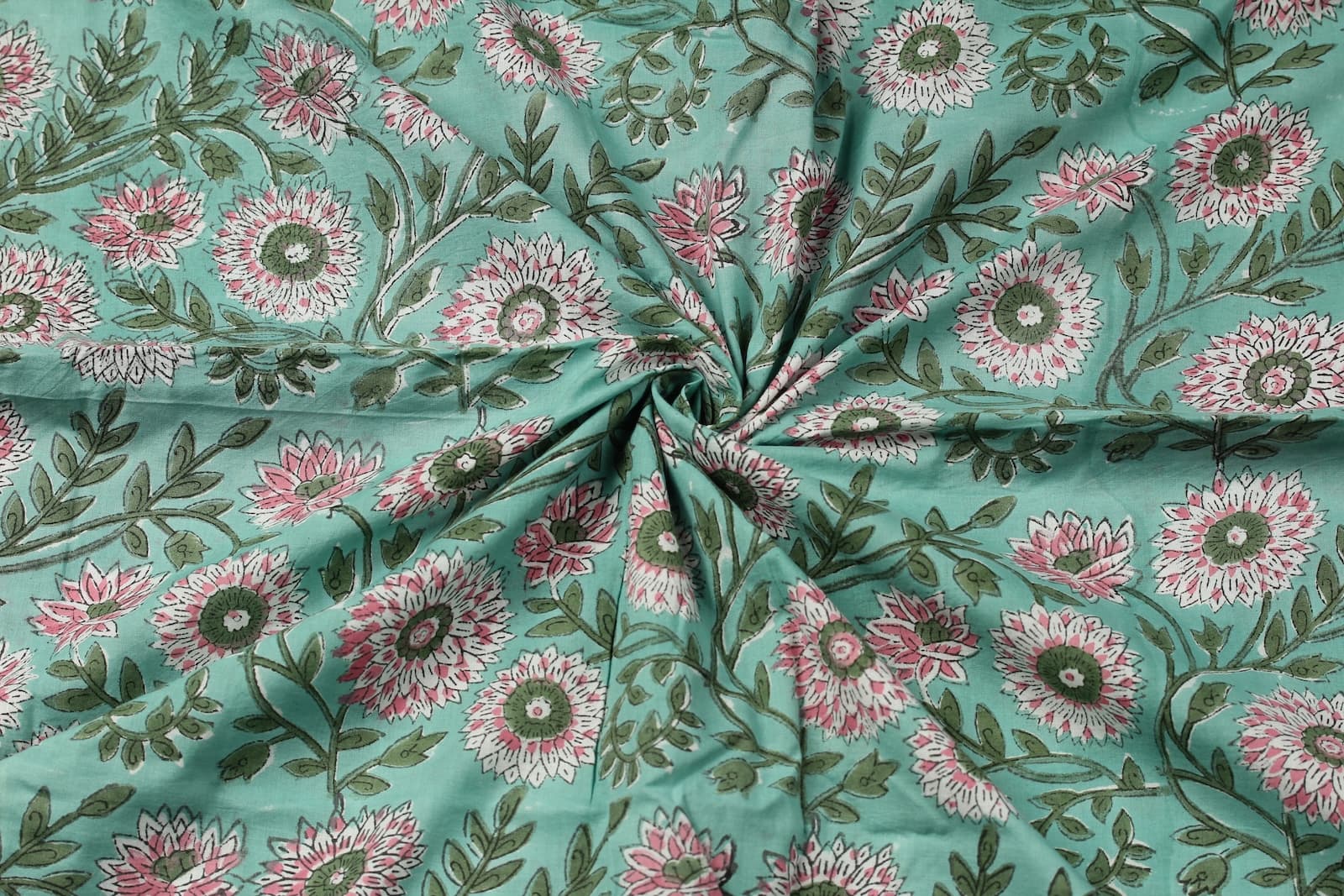 Hand block printed aqua cotton fabric draped to display floral chrysanthemum pattern and fabric texture