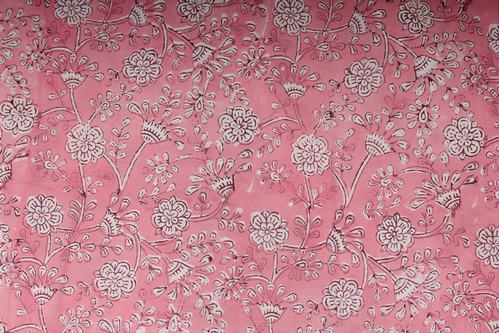 Close-up of Blush Marigold Sprig block printed cotton fabric showing delicate ivory floral motifs and trailing botanical stems