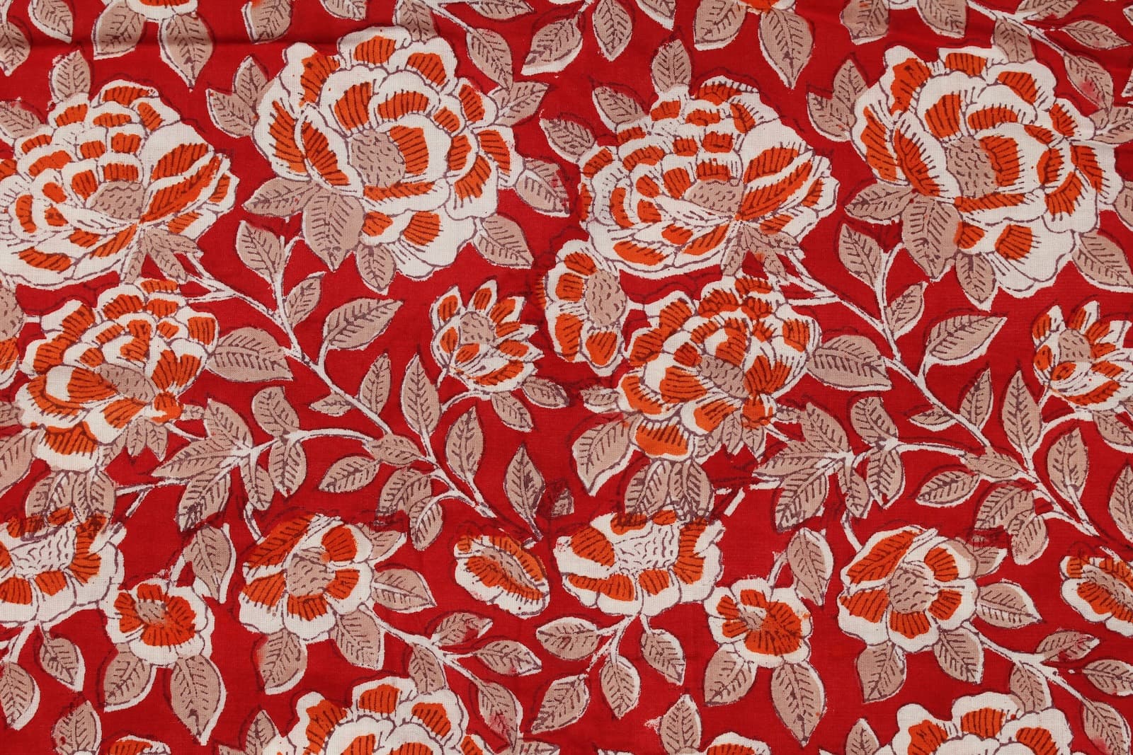 Close-up of Crimson Rosewood block printed cotton fabric showing hand-printed rose motifs and delicate foliage details