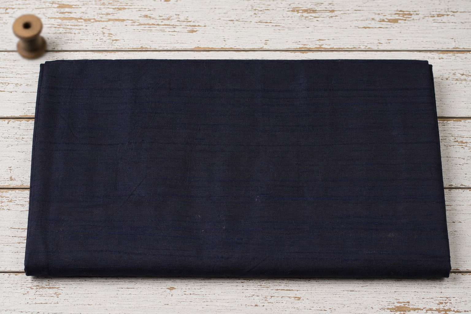 Deep Navy Dupion Silk Fabric folded to display its rich midnight blue colour, natural silk texture, and elegant sheen