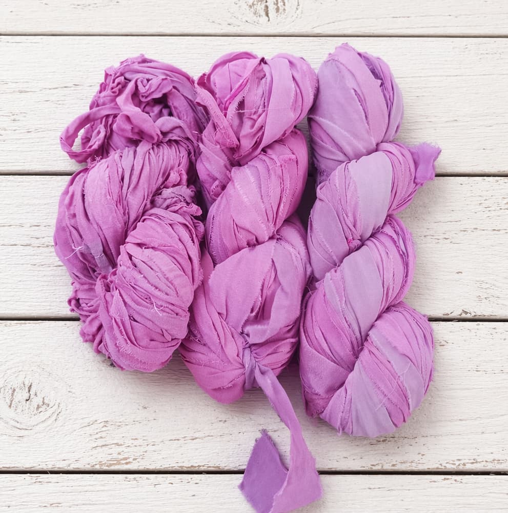 Multiple skeins of Orchid Blossom chiffon silk ribbon yarn in soft pink and mauve shades