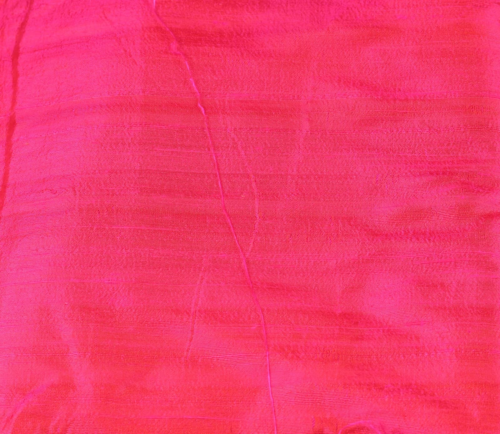 Close-up of Electric Fuchsia dupion silk fabric showing raw silk texture and vivid pink colour with lustrous finish