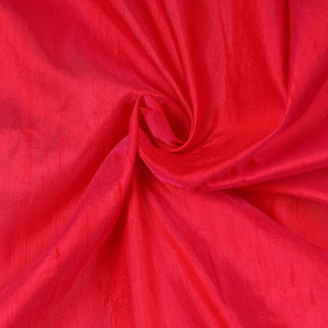 Electric Pink Dupion Silk Fabric arranged in elegant swirling folds highlighting its lustrous sheen and natural dupion silk texture