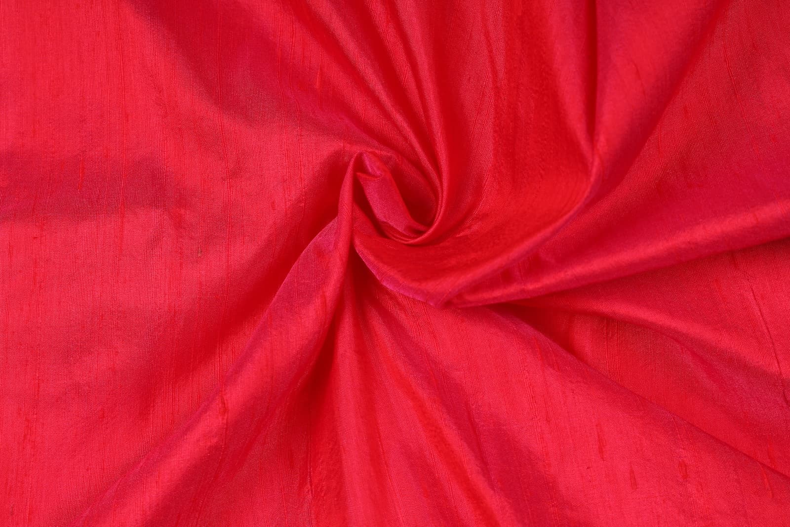 Electric Pink Dupion Silk Fabric arranged in elegant swirling folds highlighting its lustrous sheen and natural dupion silk texture