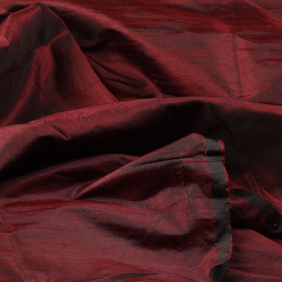 Ruby red raw silk fabric displaying the crisp drape of Dupion silk.