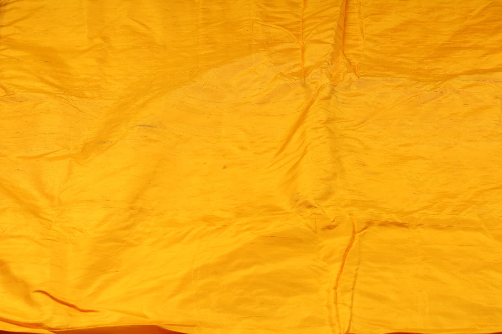 Close-up of Golden Marigold Dupion Silk Fabric showing natural slub texture, woven silk detail, and subtle colour variation