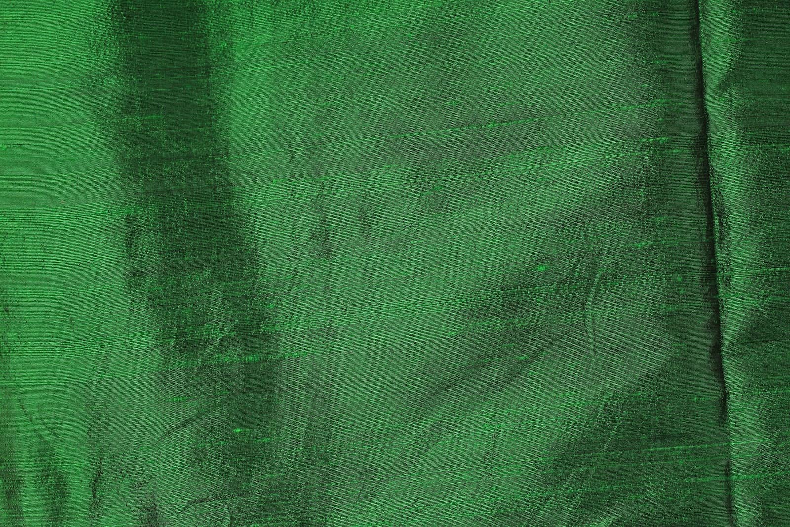 Emerald Green Dupion Silk Fabric displayed in flowing folds revealing its crisp texture, silk lustre, and deep emerald colouring