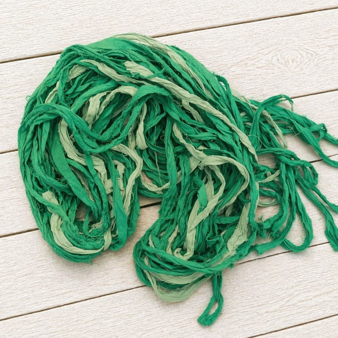 Recycled sari silk ribbon yarn bundle showing fern green and sage silk strands