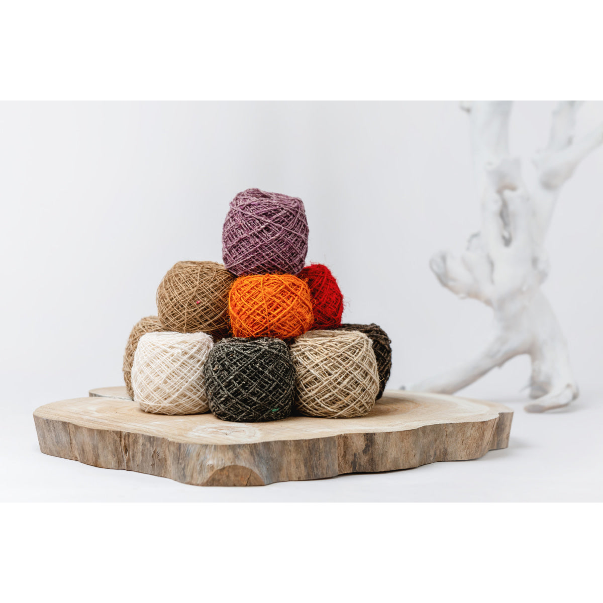 Hemp Yarn – hand-spun and hand-dyed Himalayan yarn in orange, yellow, white, and lavender skeins arranged together