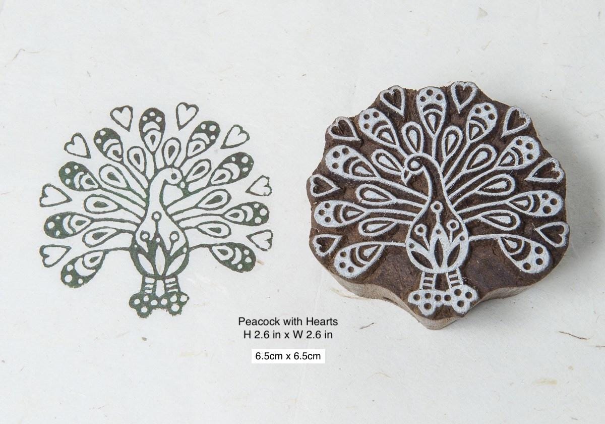 Hand carved peacock with hearts wooden block printing stamp shown with printed impression on paper.