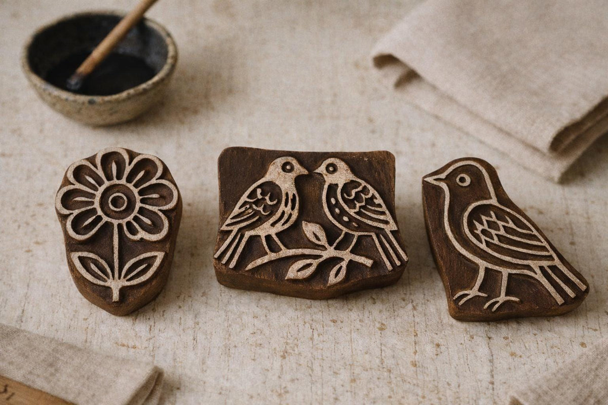 Hand carved wooden printing blocks featuring flower, single bird, and love birds design on rustic background