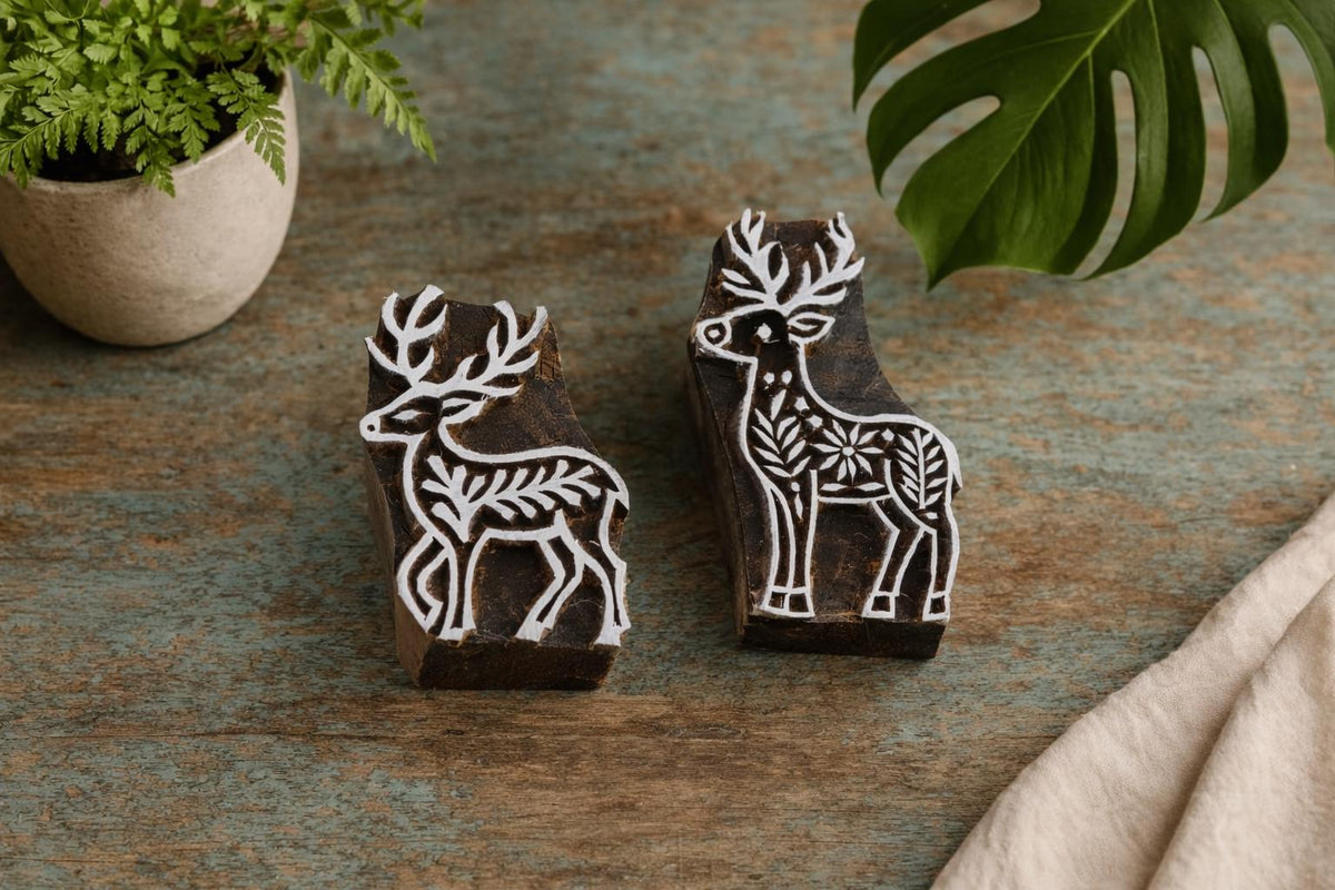 Set of two handmade wooden deer block printing stamps on rustic surface