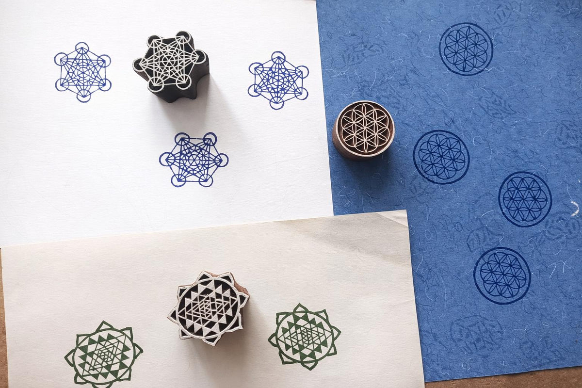 Hand carved sacred geometry block printing stamps showing Metatron cube, Sri Yantra and Flower of Life prints on handmade paper.
