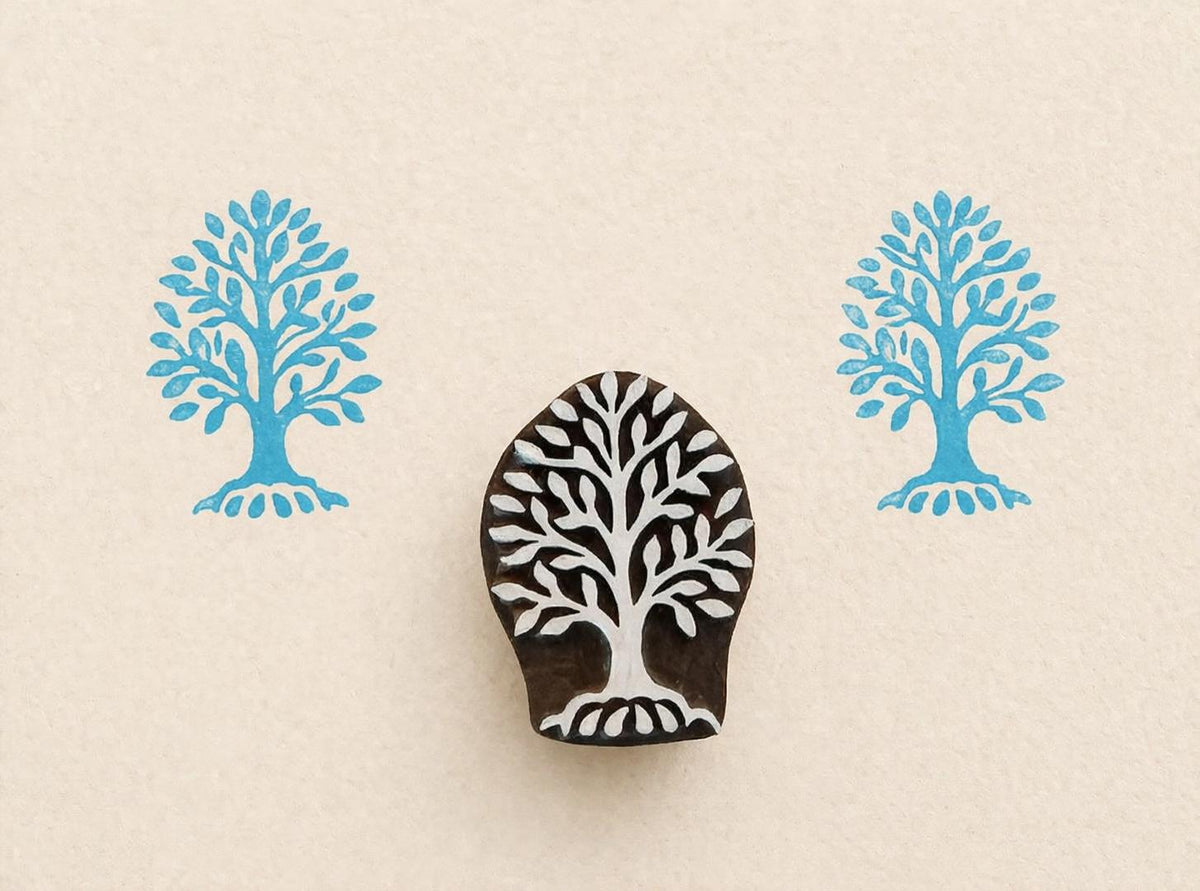 Hand carved wooden tree stamp featuring roots and full canopy printed in blue ink on neutral paper