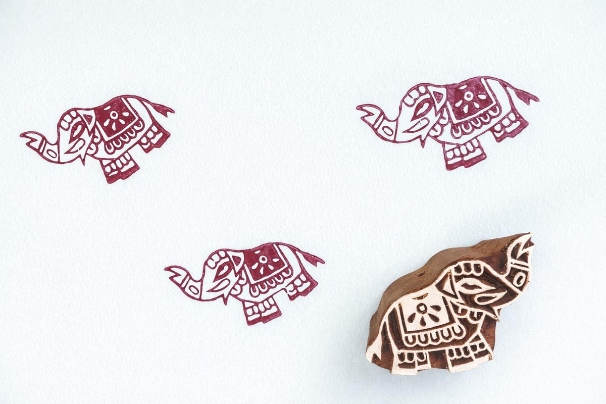 Small elephant wooden block stamp with red printed pattern on paper