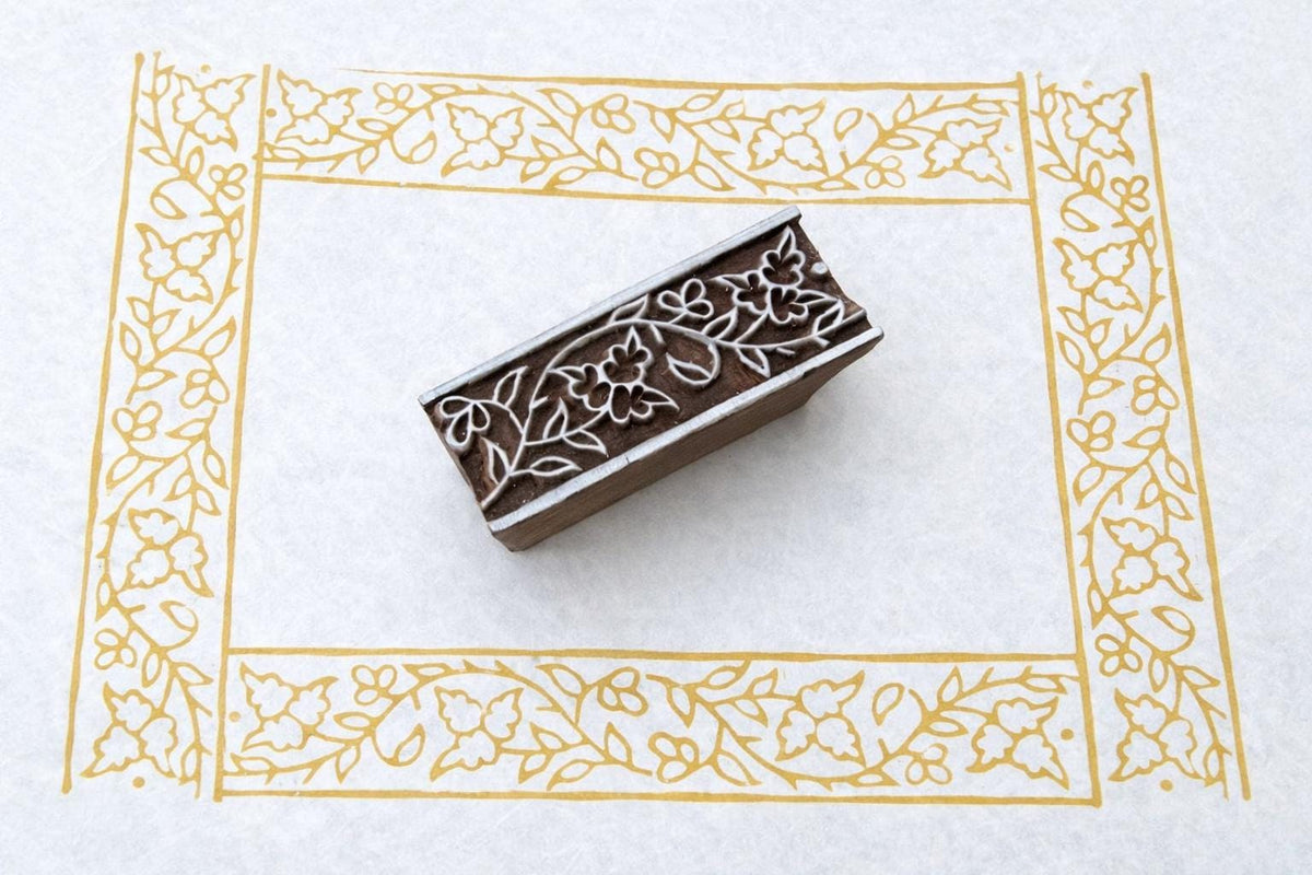 Hand carved wooden stamp printing floral vine border pattern with flowers and leaves