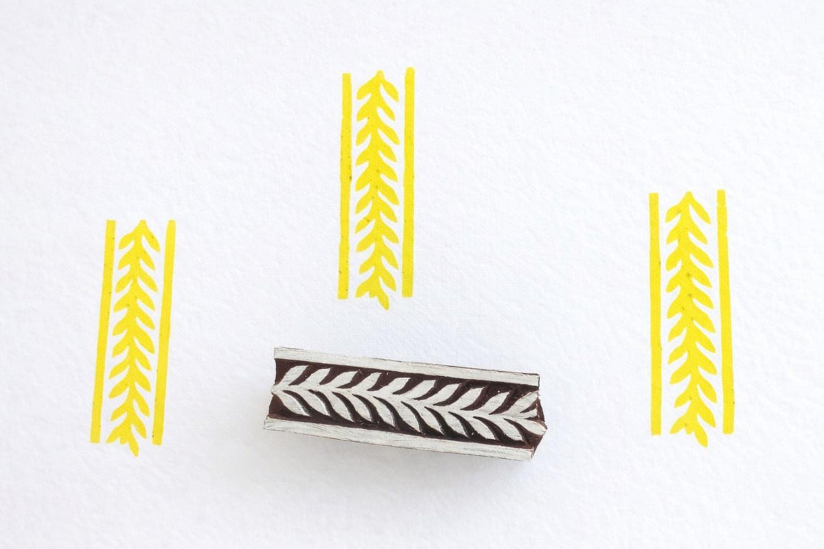 Hand carved wooden stamp printing repeating leaf chevron border pattern