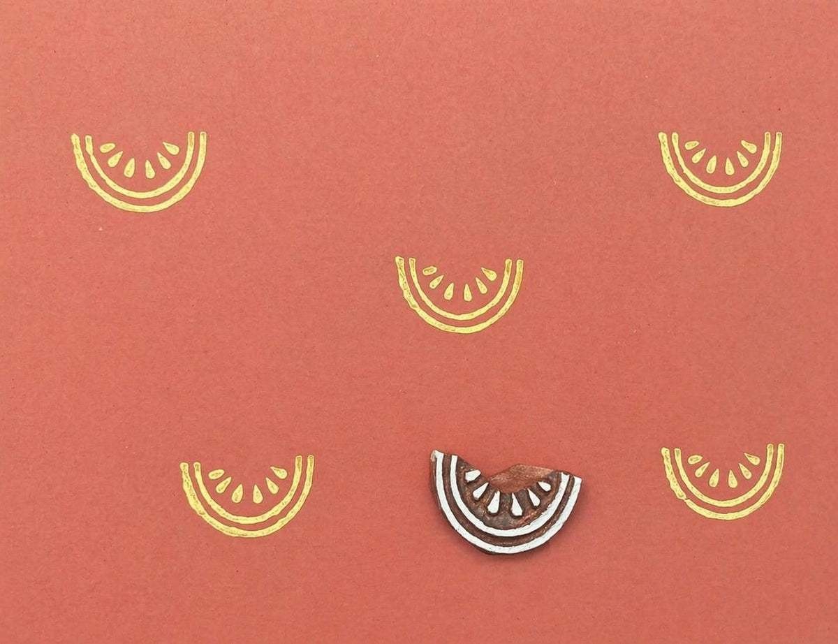 Watermelon slice stamp with repeating fruit pattern on coral background