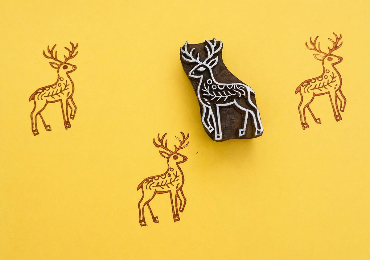 Hand carved wooden block printing stamp featuring a deer motif, used to create repeating animal patterns on fabric, paper, or walls.