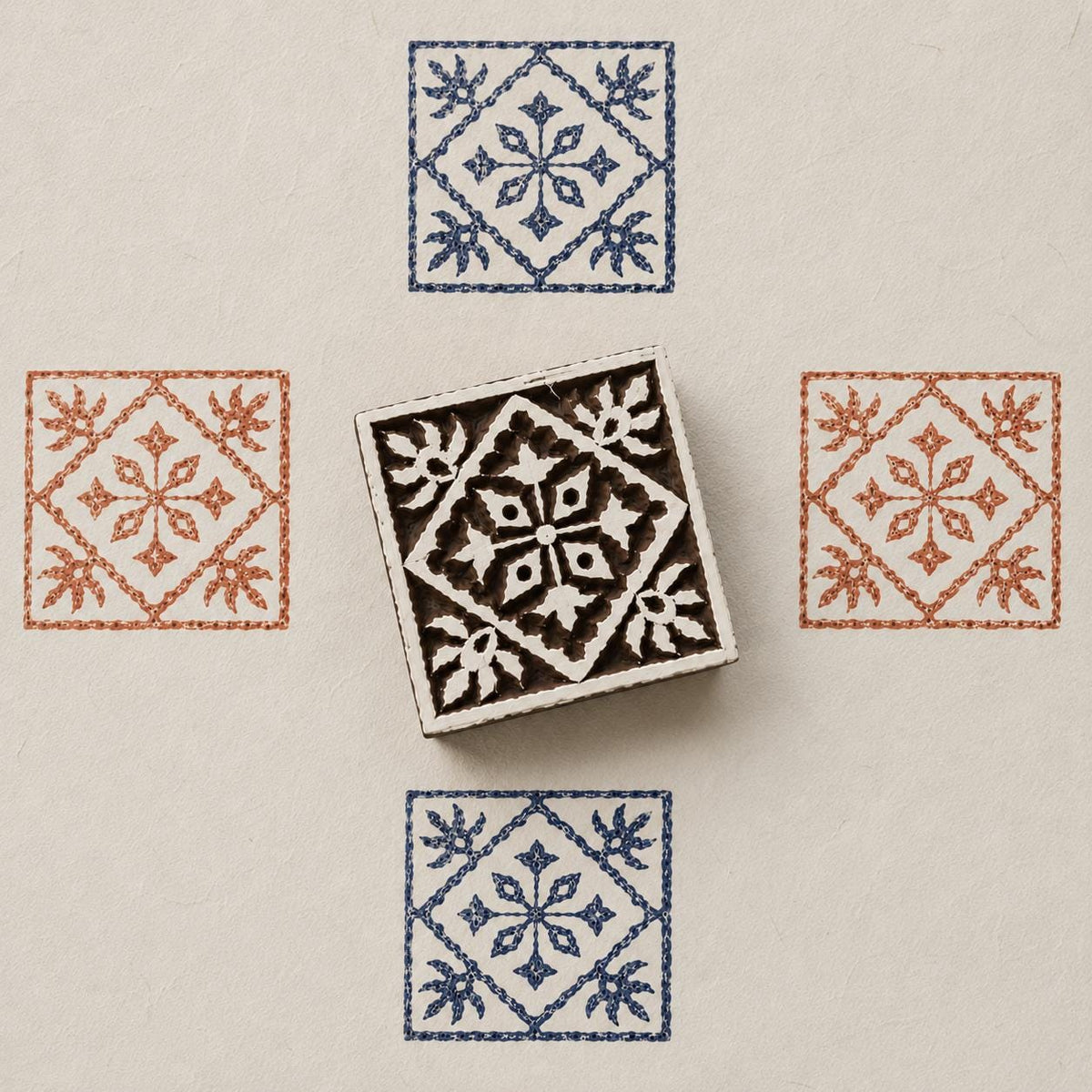 Hand carved Indian wooden block featuring heritage tile motif printed in blue and terracotta on textured cream background for textile printing, pottery, clay, and paper crafts.