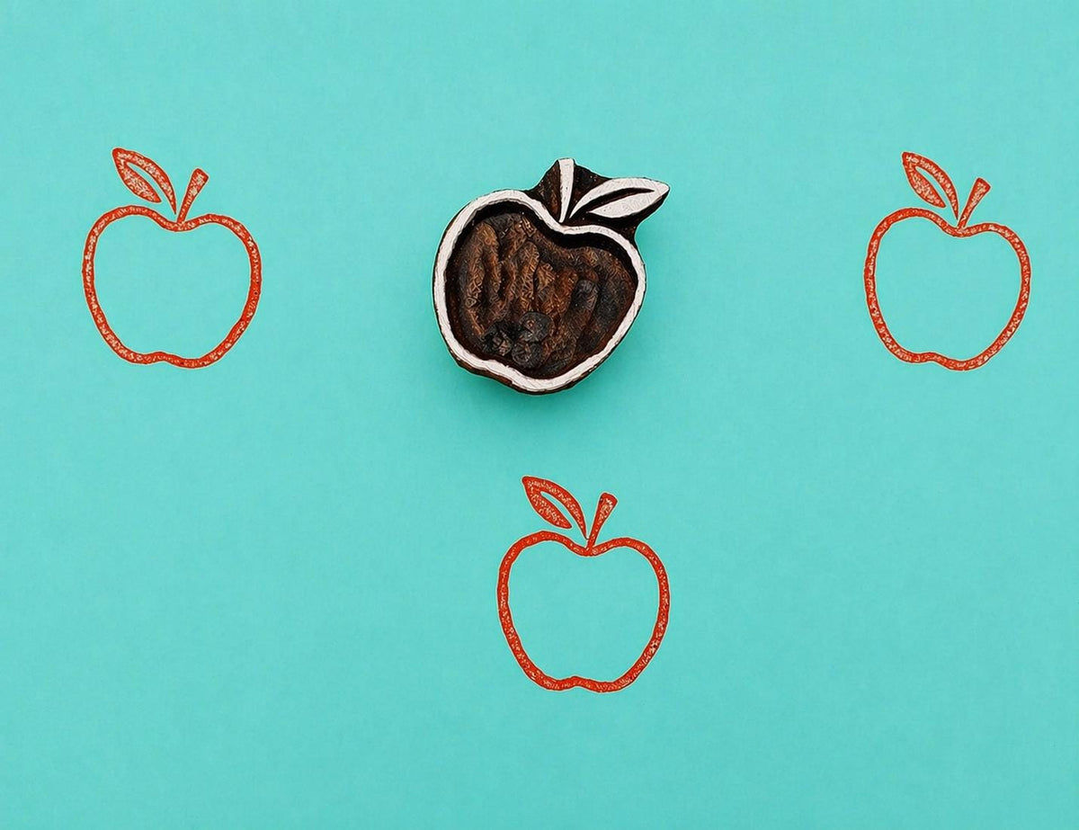 Hand carved wooden printing block with a simple apple design for fabric printing, block print patterns, and paper crafts.