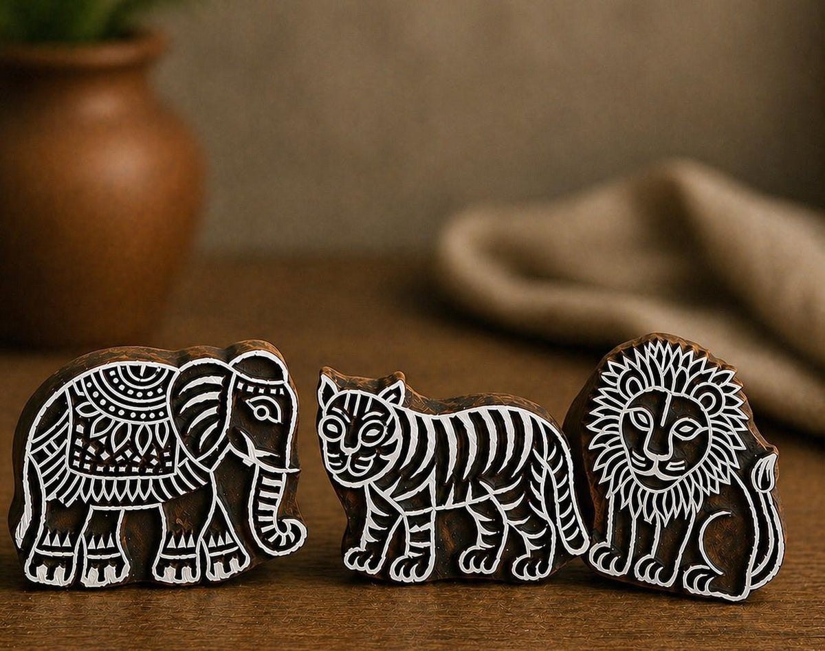 Hand carved wooden block stamp set featuring elephant, tiger and lion animal designs on rustic wooden background