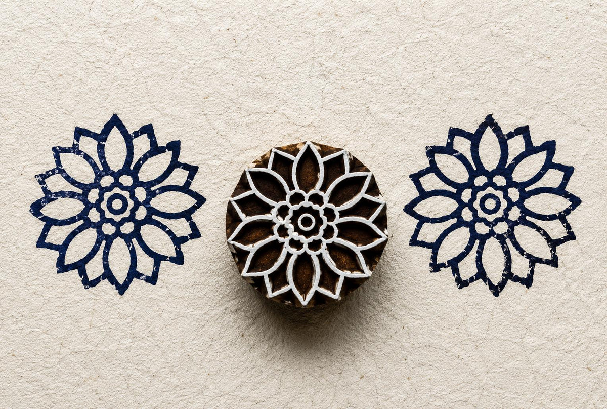 Hand carved Sunwheel wood block stamp with deep blue geometric folk art impressions on handmade paper