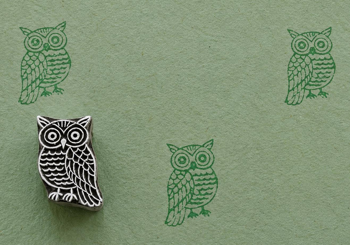 Hand carved owl wooden stamp with folk art bird impressions on textured handmade paper