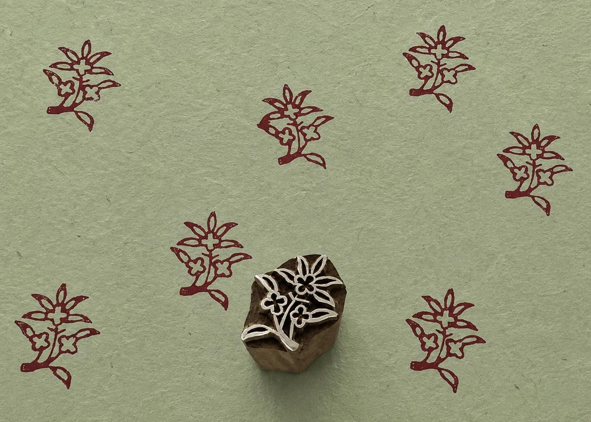 Hand carved Spring Posy wooden block stamp with burgundy floral impressions on sage green handmade paper.