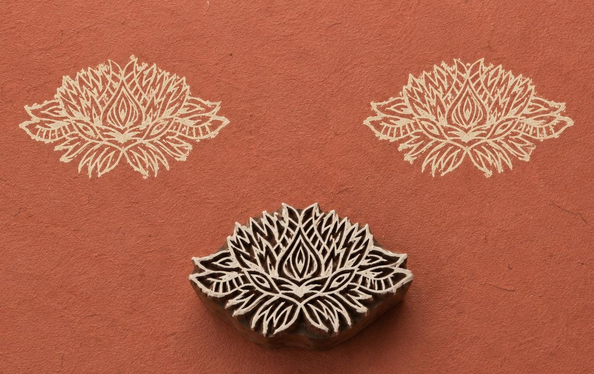 Hand carved Indian wooden printing block featuring an ornate radiant mandala motif stamped on terracotta handmade paper, suitable for fabric printing, pottery decoration, clay impressions, and decorative craft projects.