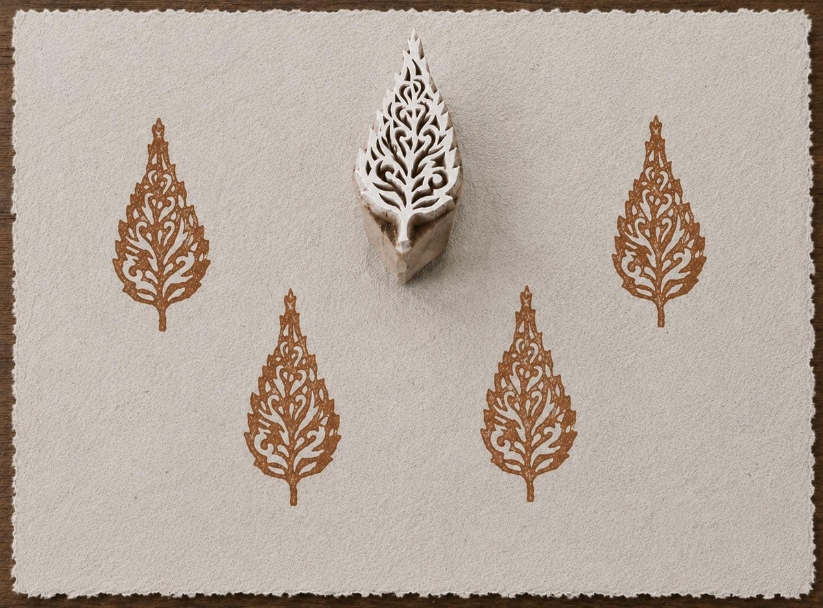 Hand carved ornate botanical leaf wooden printing block with repeated leaf impressions on handmade paper