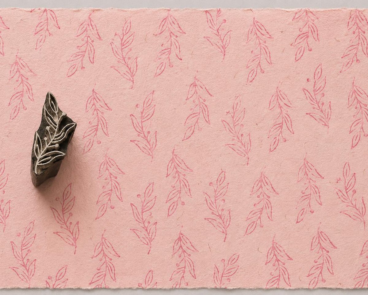 Hand carved Berry Branch wooden printing block with soft pink botanical impressions on handmade blush paper.