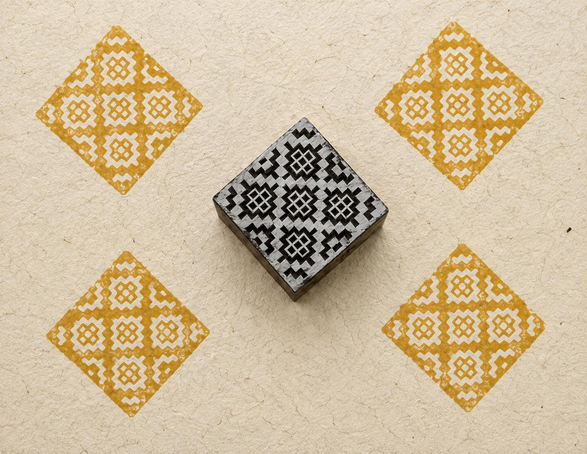 Hand carved wooden stamp printing yellow diamond geometric pattern on fabric