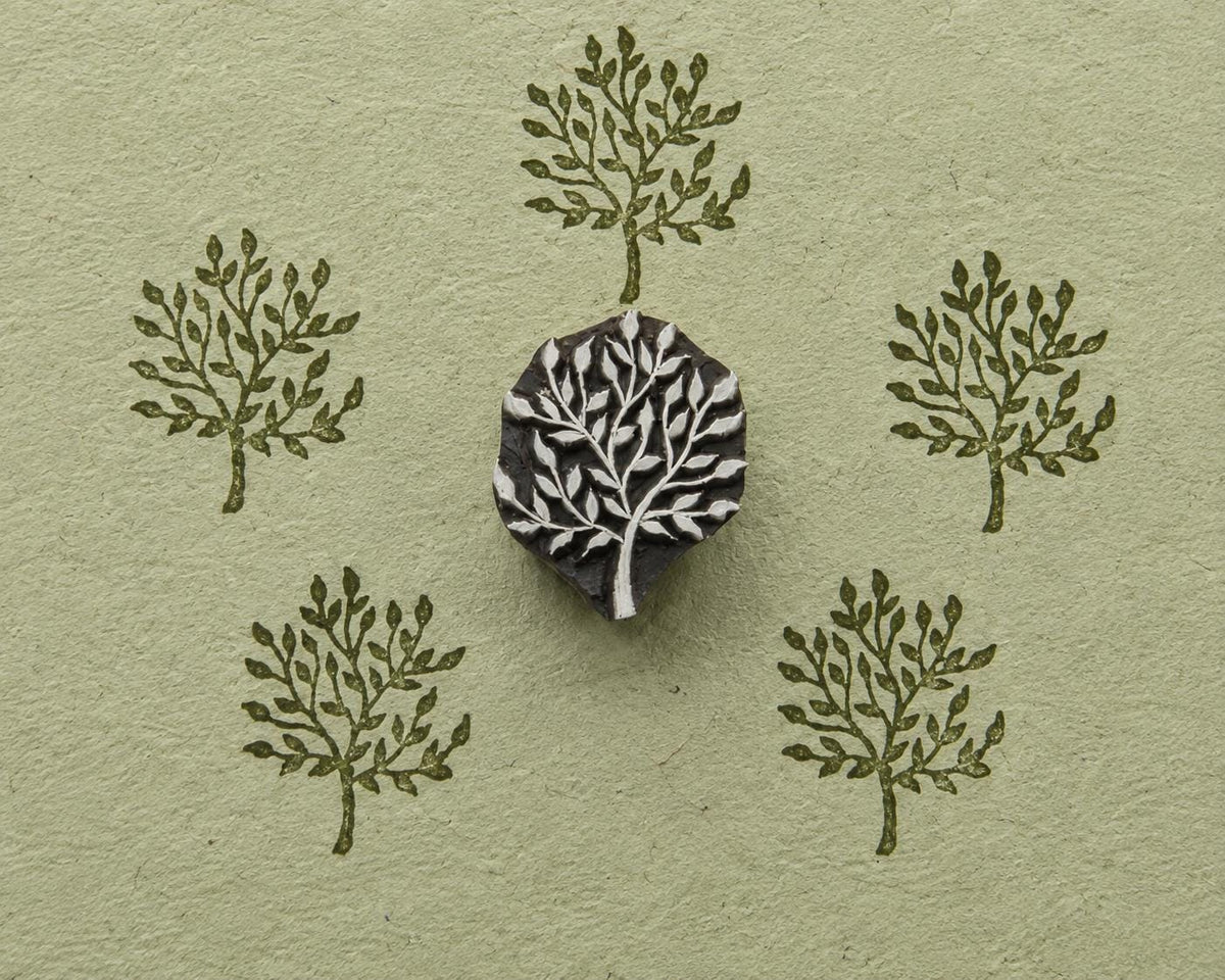 Hand carved wooden Meadow Tree stamp shown with repeated leafy tree impressions on textured handmade paper.