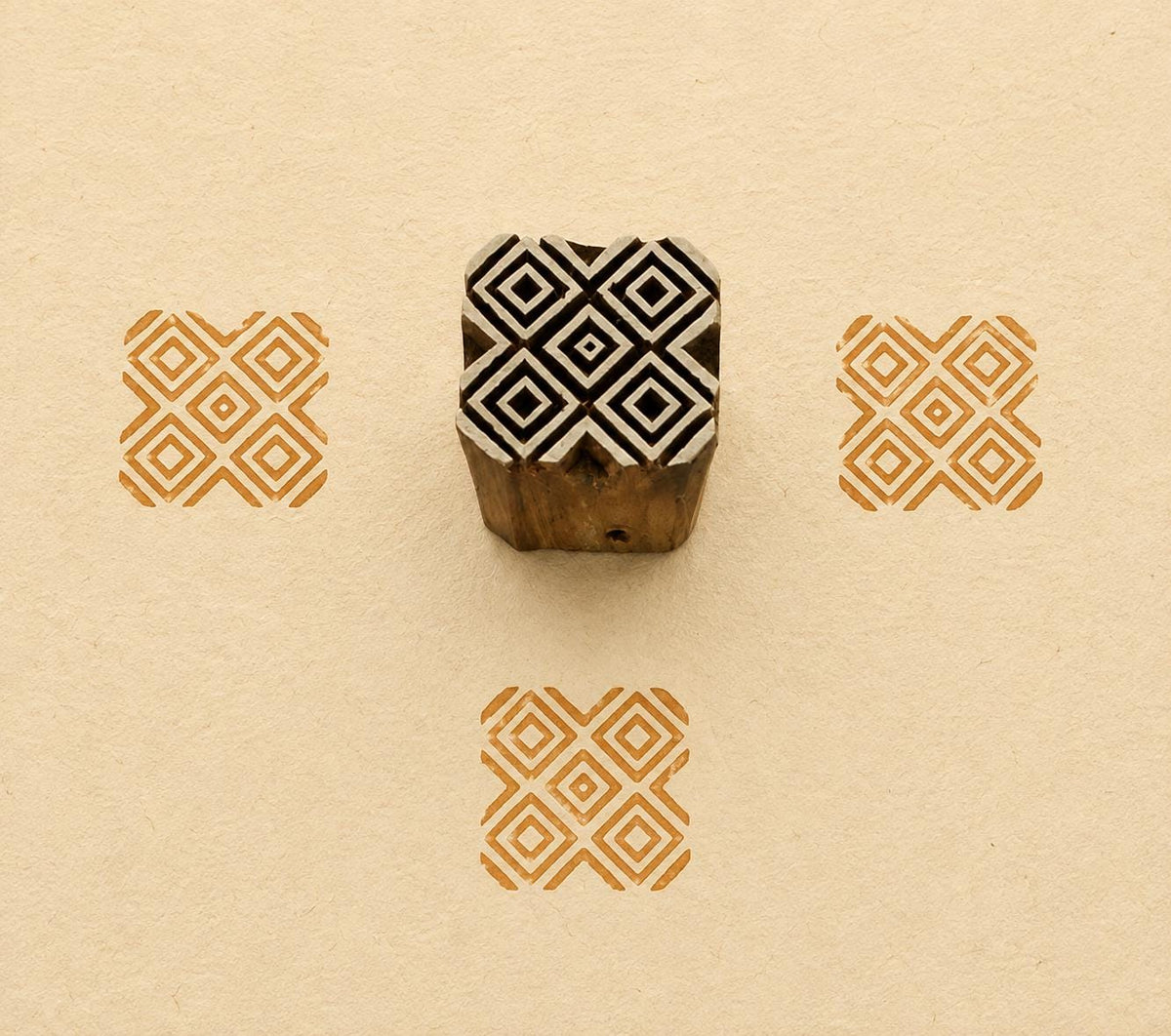 Hand carved Indian wooden textile printing block featuring a Temple Diamonds geometric pattern with nested diamonds, stamped in ochre on handmade paper.