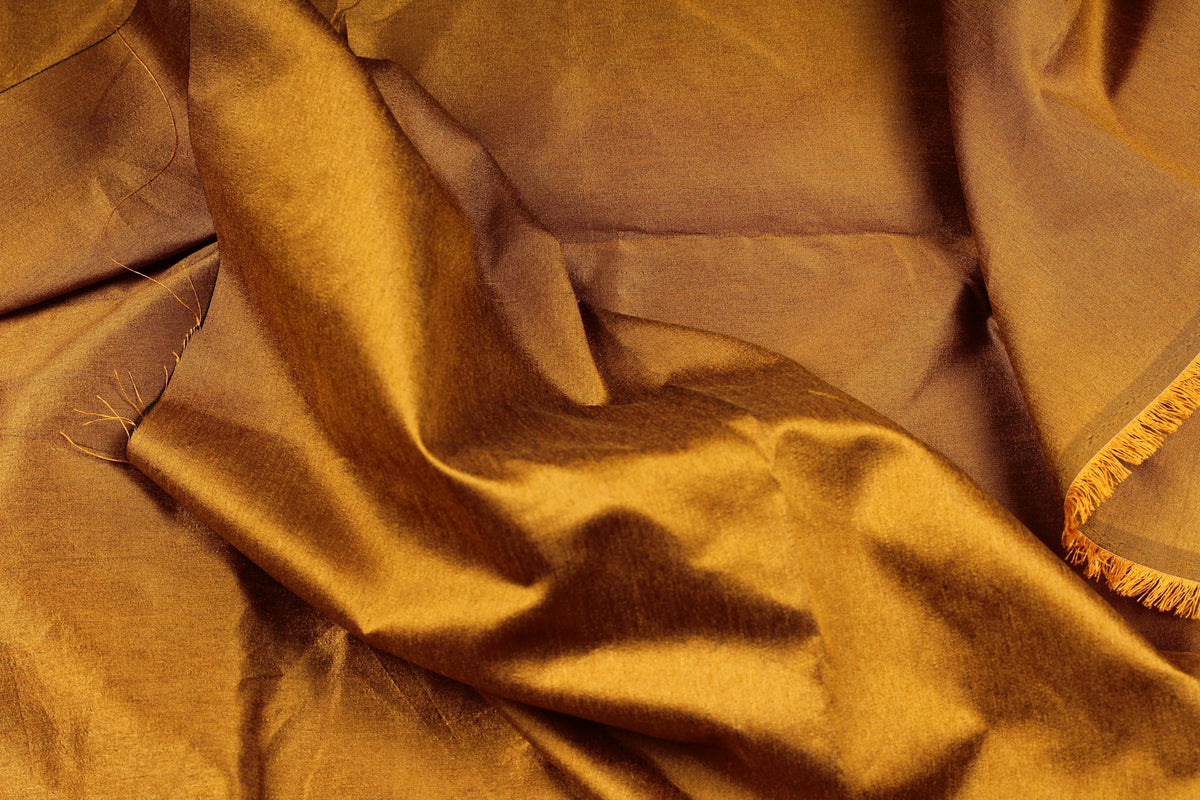 Burnt caramel faux silk dupioni fabric draped in soft folds, showing its textured surface and subtle sheen.