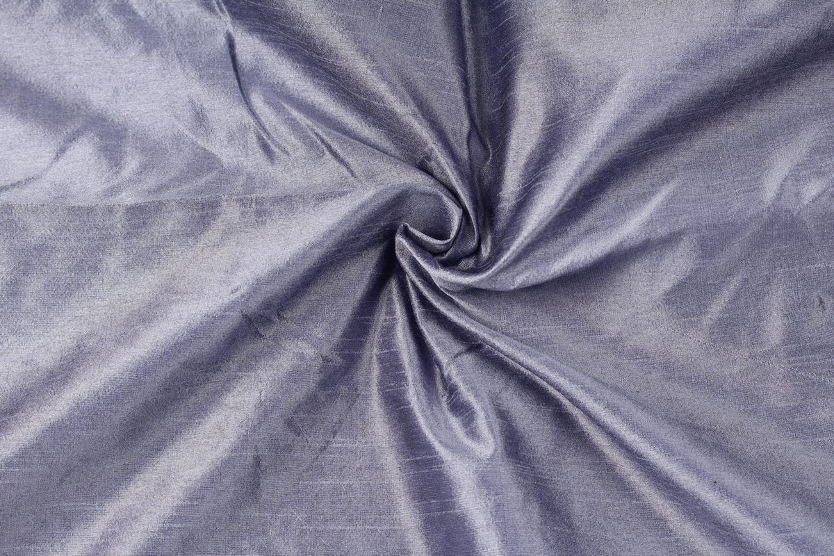 Close-up of smoky lavender faux dupioni fabric arranged in soft folds, showing its textured faux silk finish.