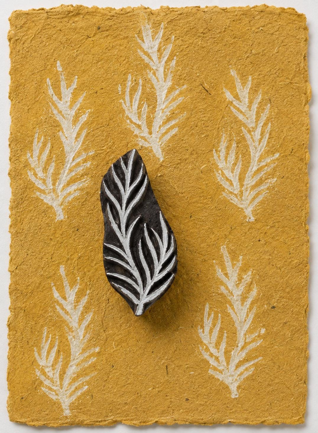 Branching leaf printing block with white botanical impressions on handmade paper