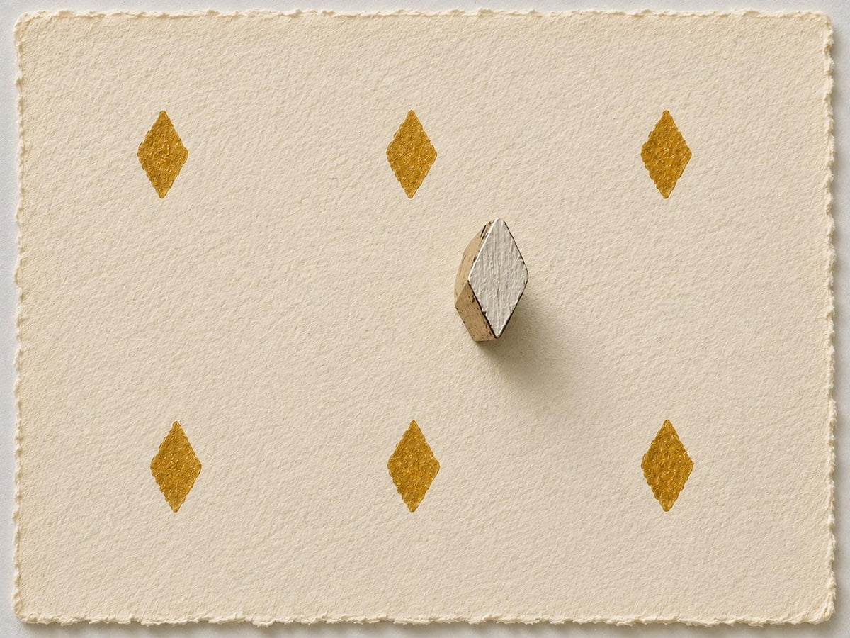 Small diamond printing block with repeated gold impressions on handmade paper