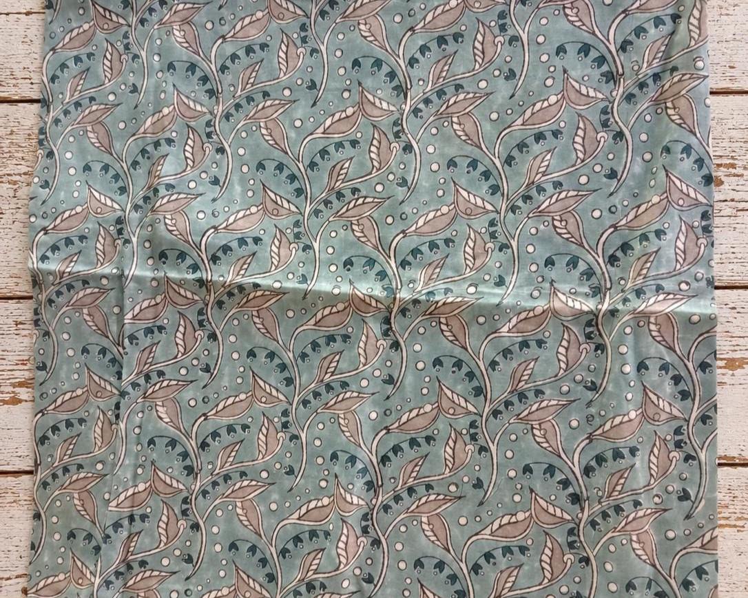 Aqua blue mulmul cotton showing the repeating Indian trailing leaf and botanical print