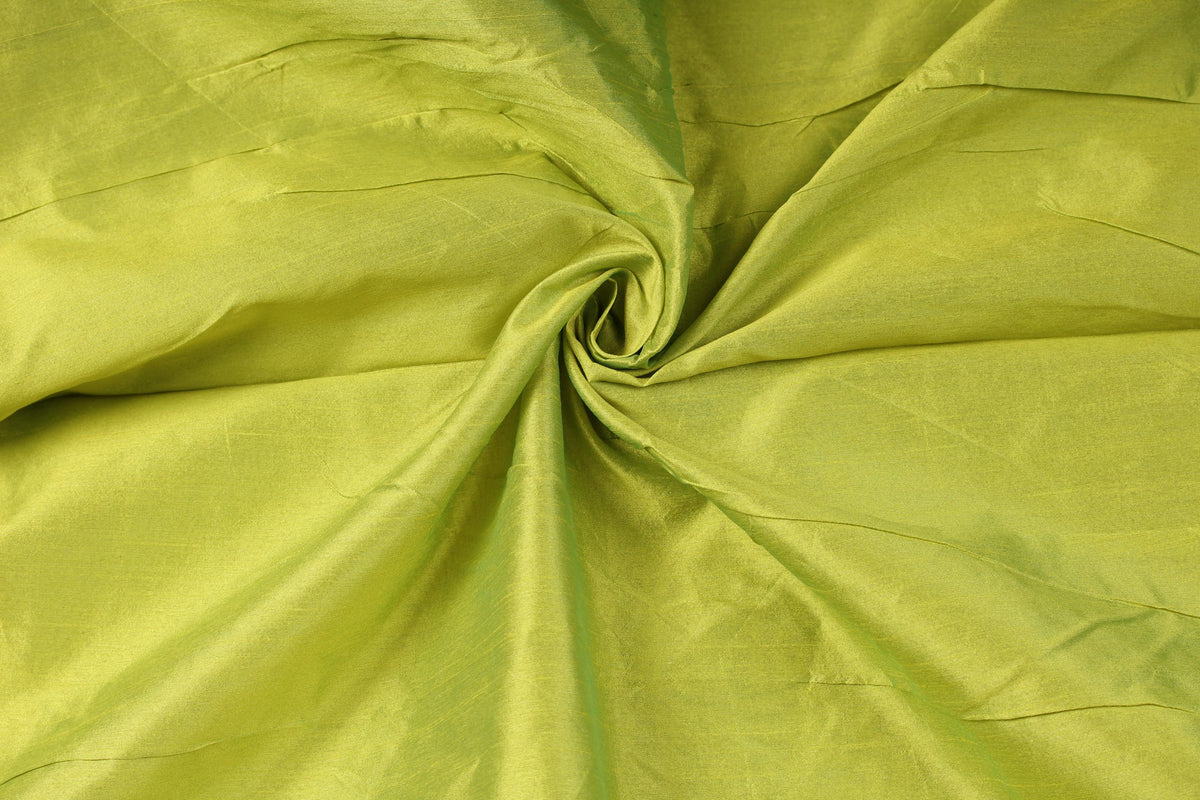Draped chartreuse faux silk dupioni fabric showing its texture, folds and subtle sheen
