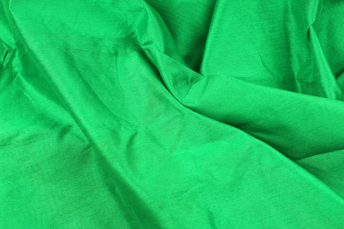 Parrot green faux silk fabric showing smooth texture and vibrant tropical green colour