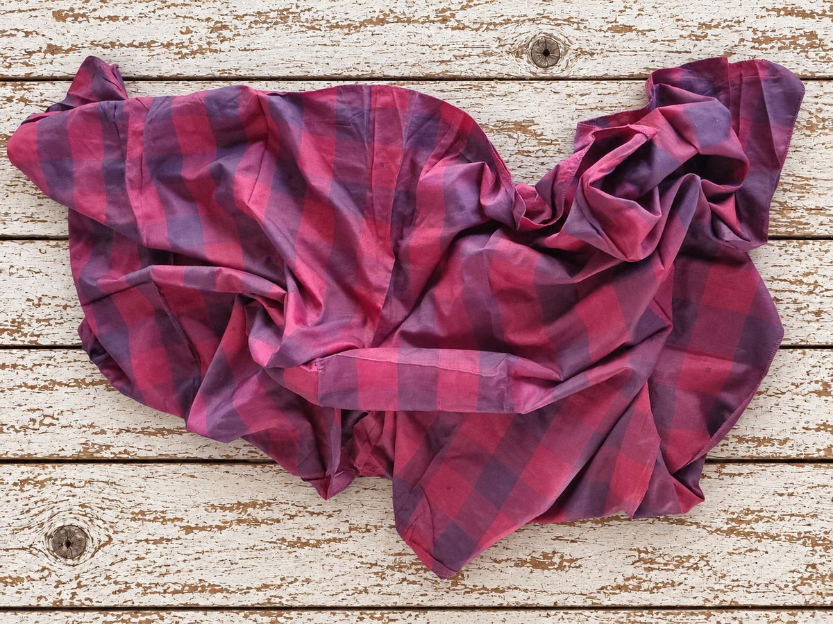 Vintage raspberry and plum plaid sari silk fabric loosely draped to show its soft flowing texture