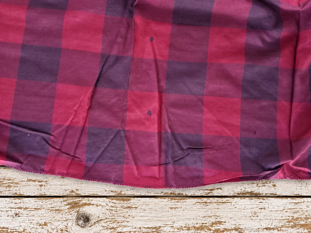 Close-up of raspberry pink and plum purple plaid silk showing the weave, colour variation and vintage character