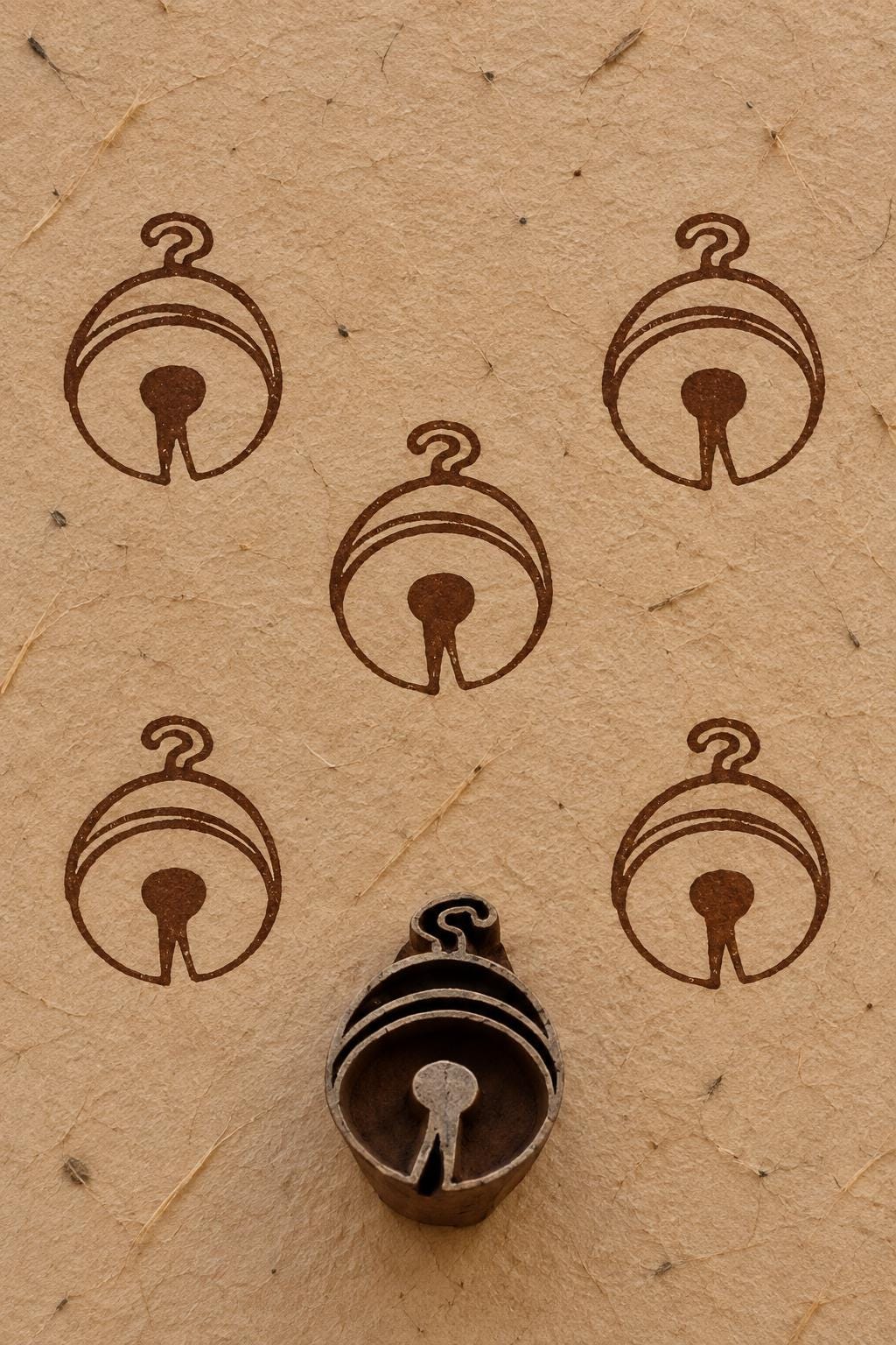 Wooden Christmas printing block featuring a simple round hanging ornament design, shown with repeated brown prints.