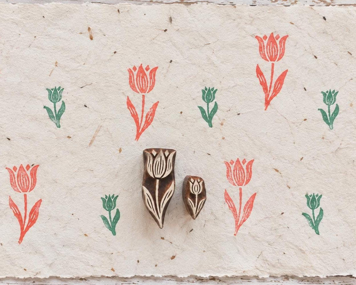 Set of two hand carved wooden tulip printing blocks with large and small tulip impressions on handmade paper.