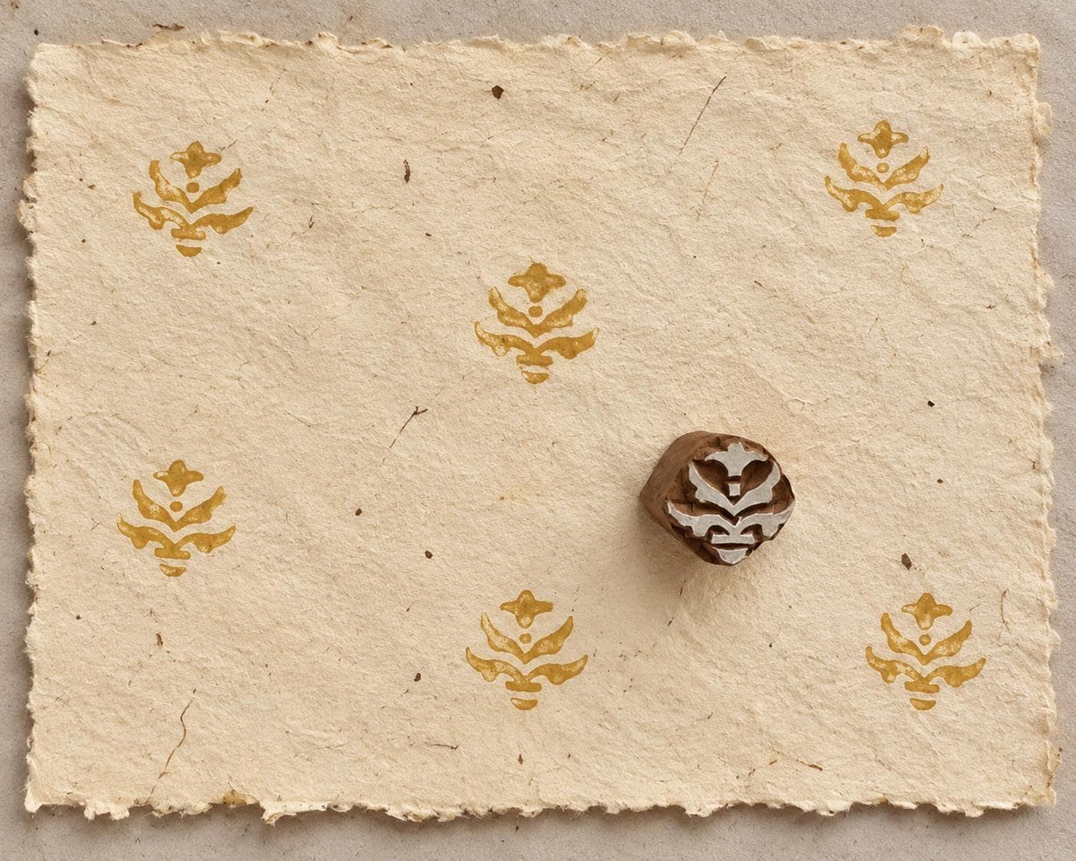 Temple Petal hand carved wooden printing block with repeated golden ornamental motifs on handmade ivory paper.