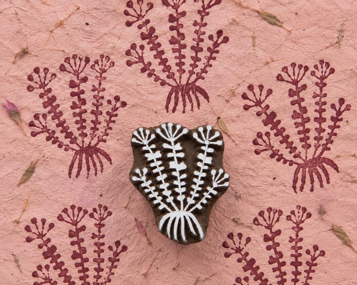 Leaf Burst hand carved wooden printing block with repeated botanical impressions on handmade pink paper.